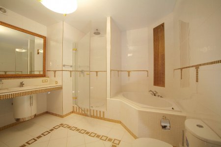 Белый натяжной потолок в ванной с люстрой