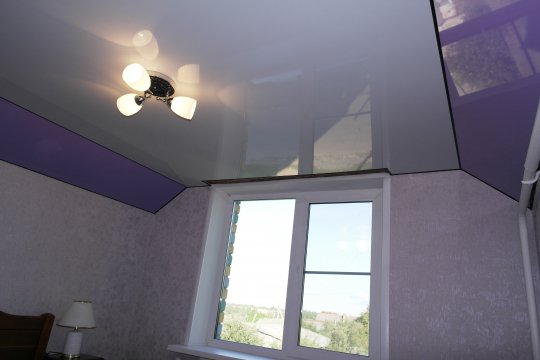 Глянцевый натяжной потолок в спальне с люстрой
